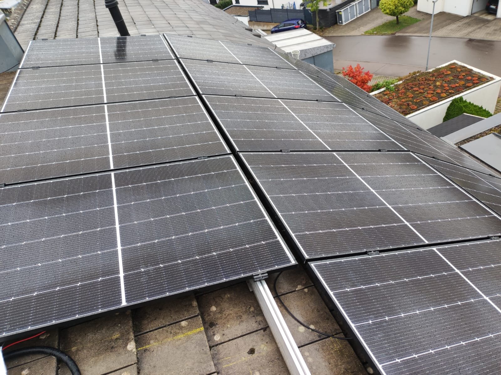 Luftaufnahme eines Ziegeldachs mit vollständig belegter Photovoltaikanlage