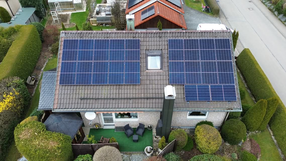 Luftaufnahme eines Einfamilienhauses mit Photovoltaikanlage und gepflegtem Garten