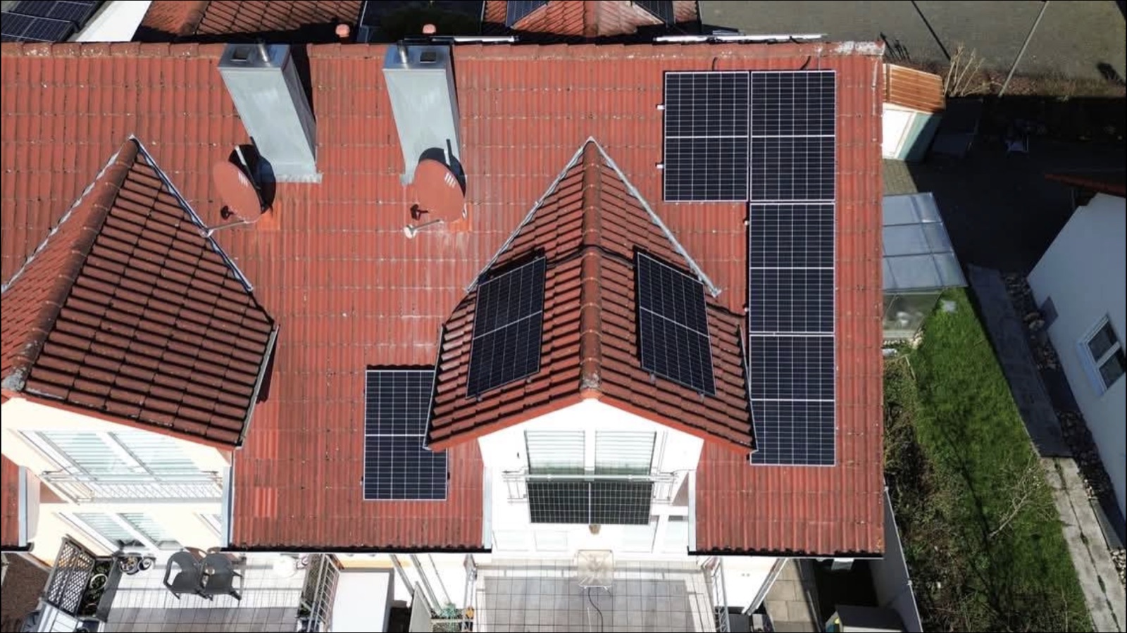 Luftaufnahme eines Walmdachs mit mehreren Photovoltaik-Modulfeldern