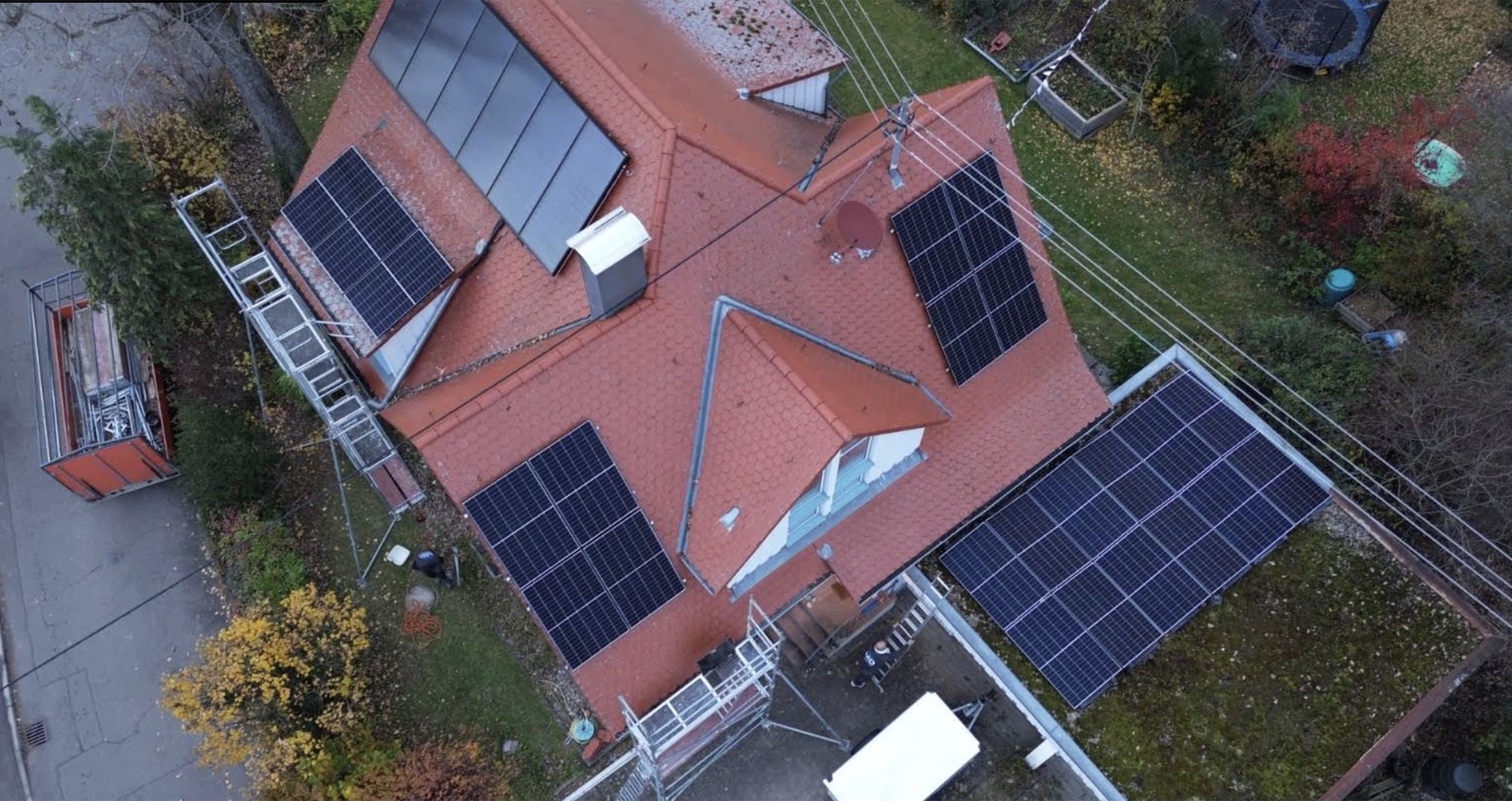 Luftaufnahme eines Dachs mit Solarthermie- und Photovoltaik-Modulen