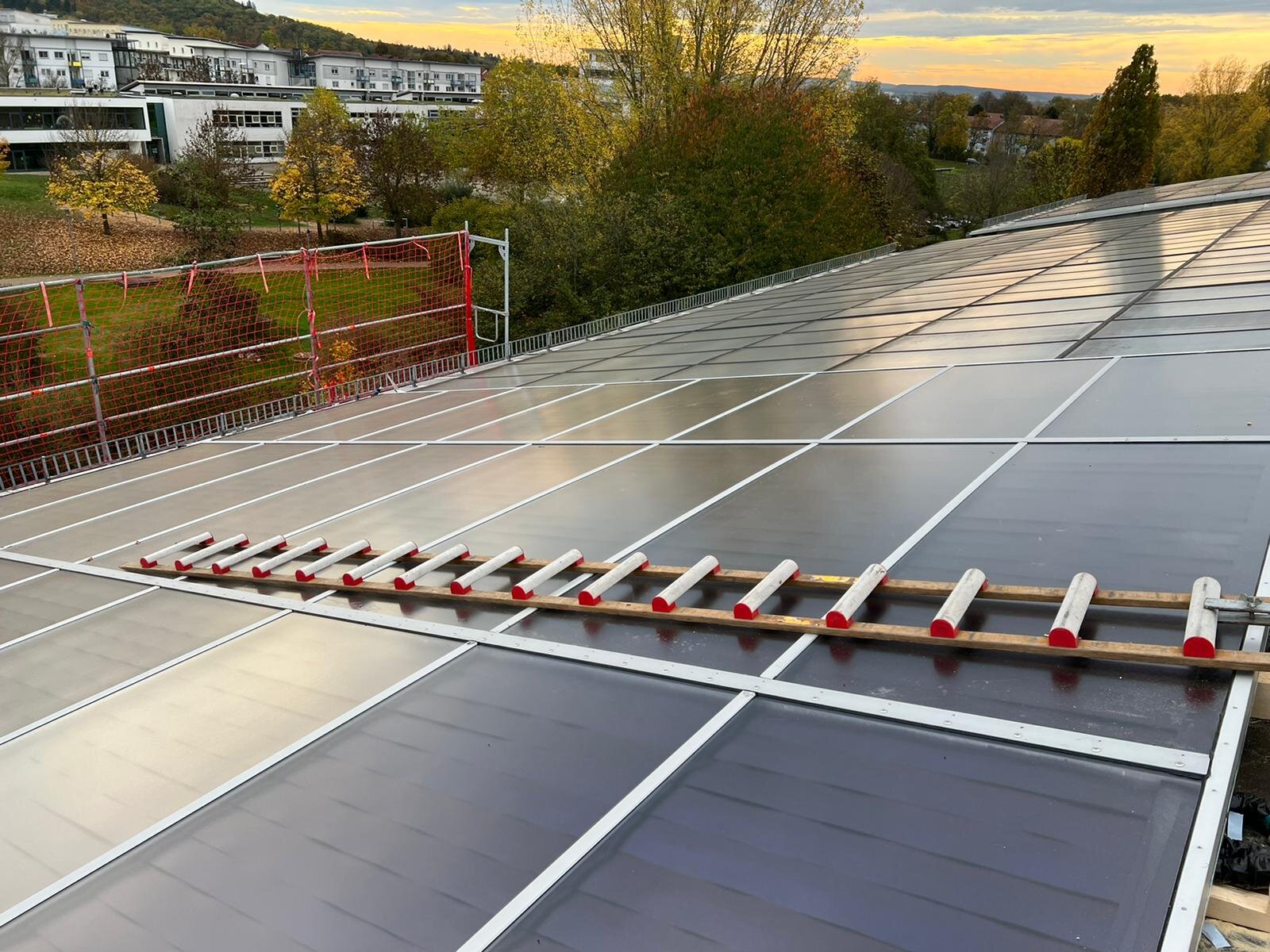 Solarthermie-Kollektoren auf einem Flachdach bei Sonnenuntergang