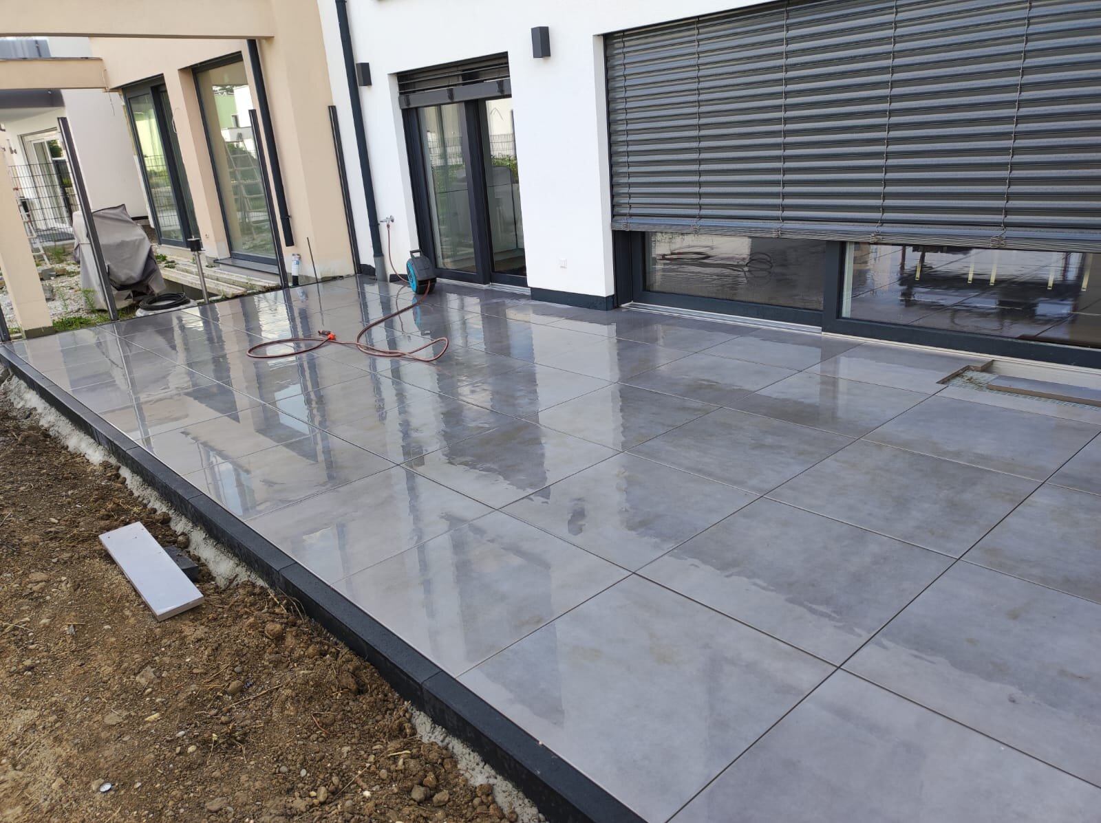 Frisch verlegte Terrassenplatten an einem Wohnhaus